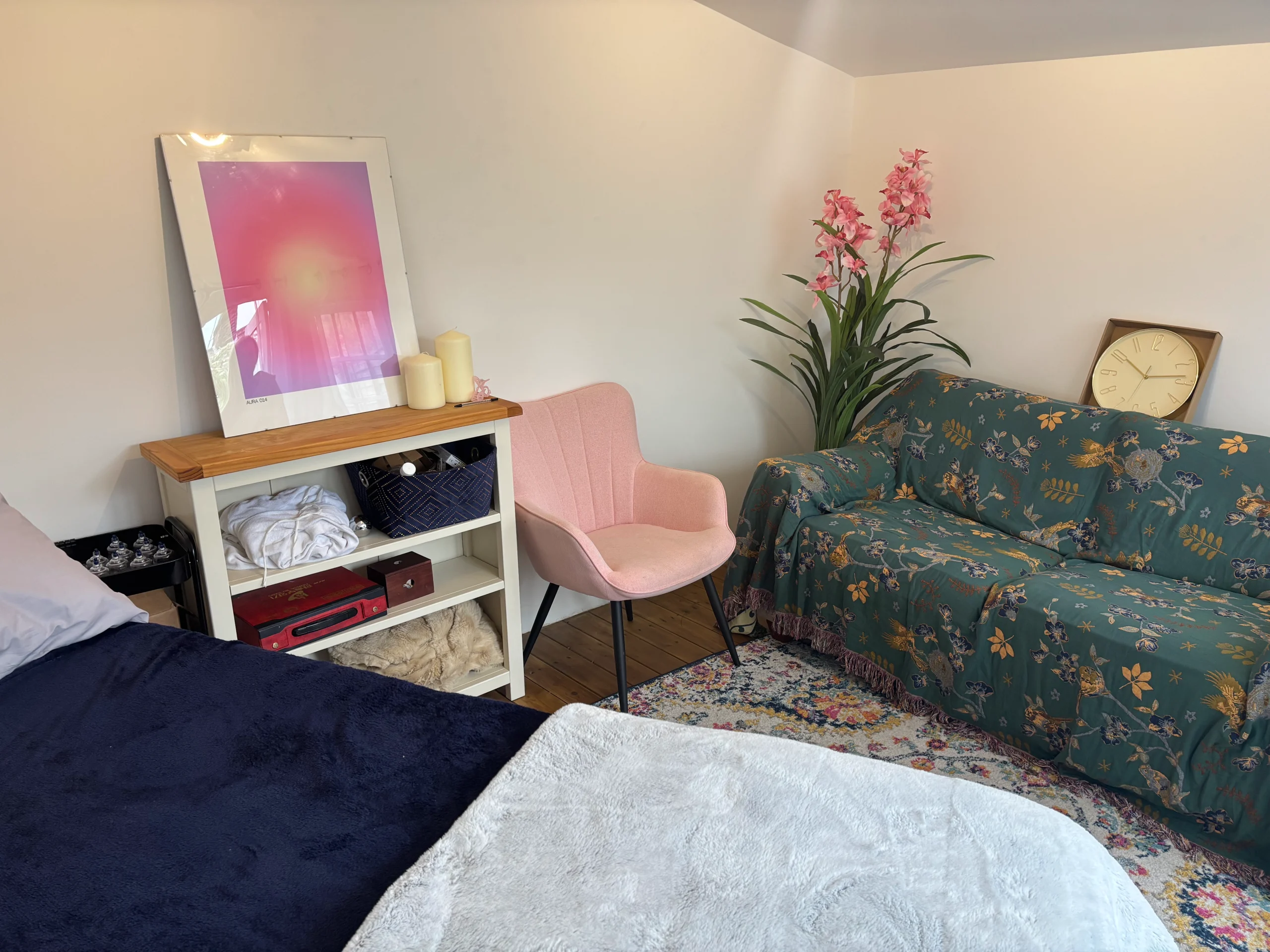 Decorated treatment room – Acupuncture or wellness treatment room with a bed, couch art on the wall, and warm decor